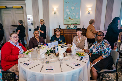People sitting at a circular table with a white tablecloth.