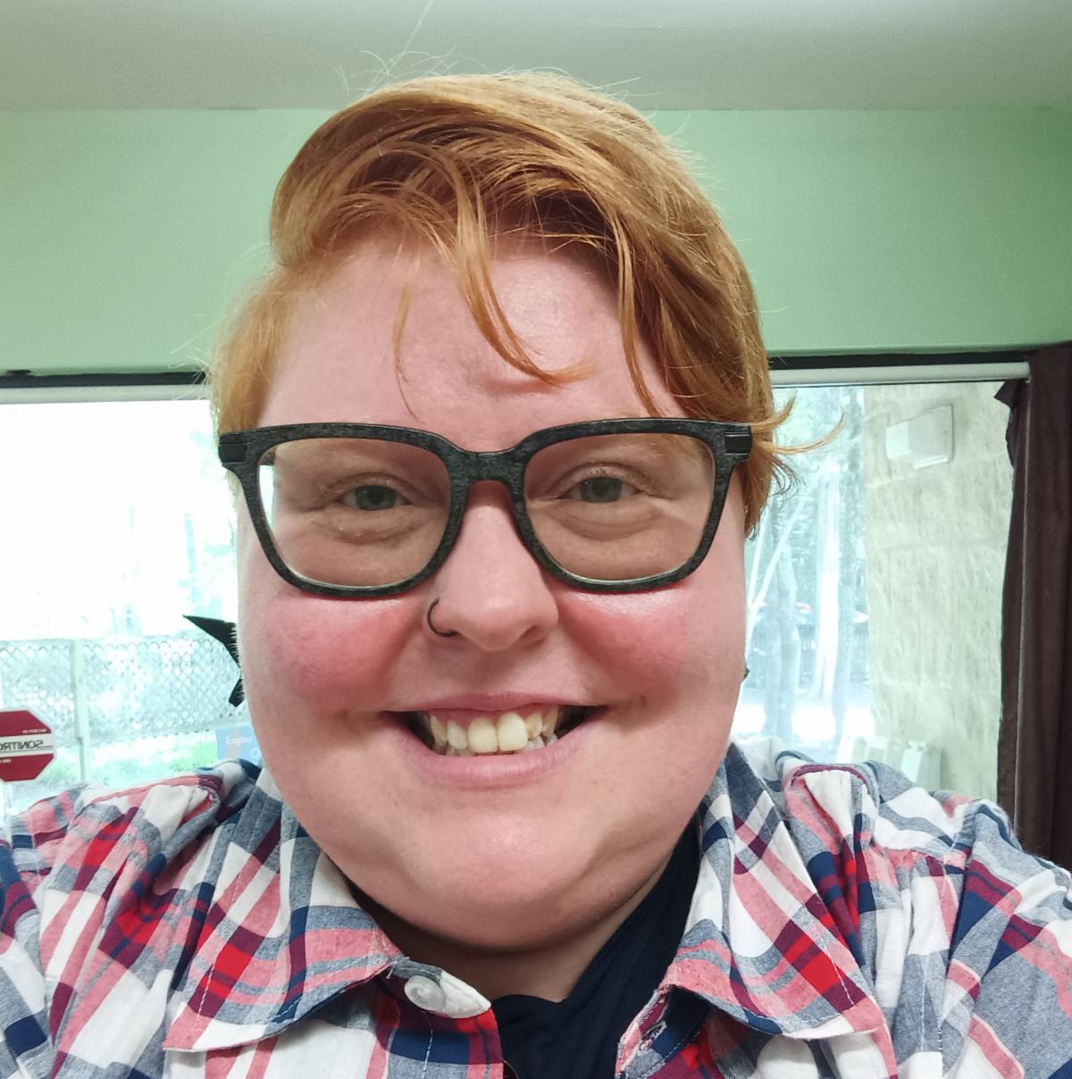 A person with glasses smiling.