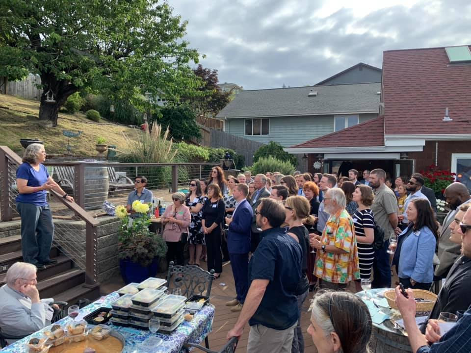Washington State House of Representatives Speaker Laurie Jinkins on some steps - speaking to a crowd in Tacoma - there is a tree in the background