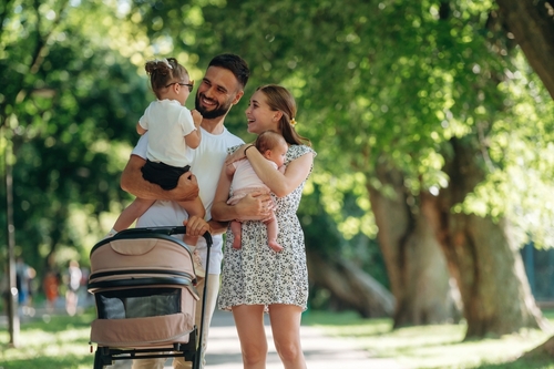 Care conception_ holding baby. Couple is with daughter_ newborn baby and cradle are having a walk.