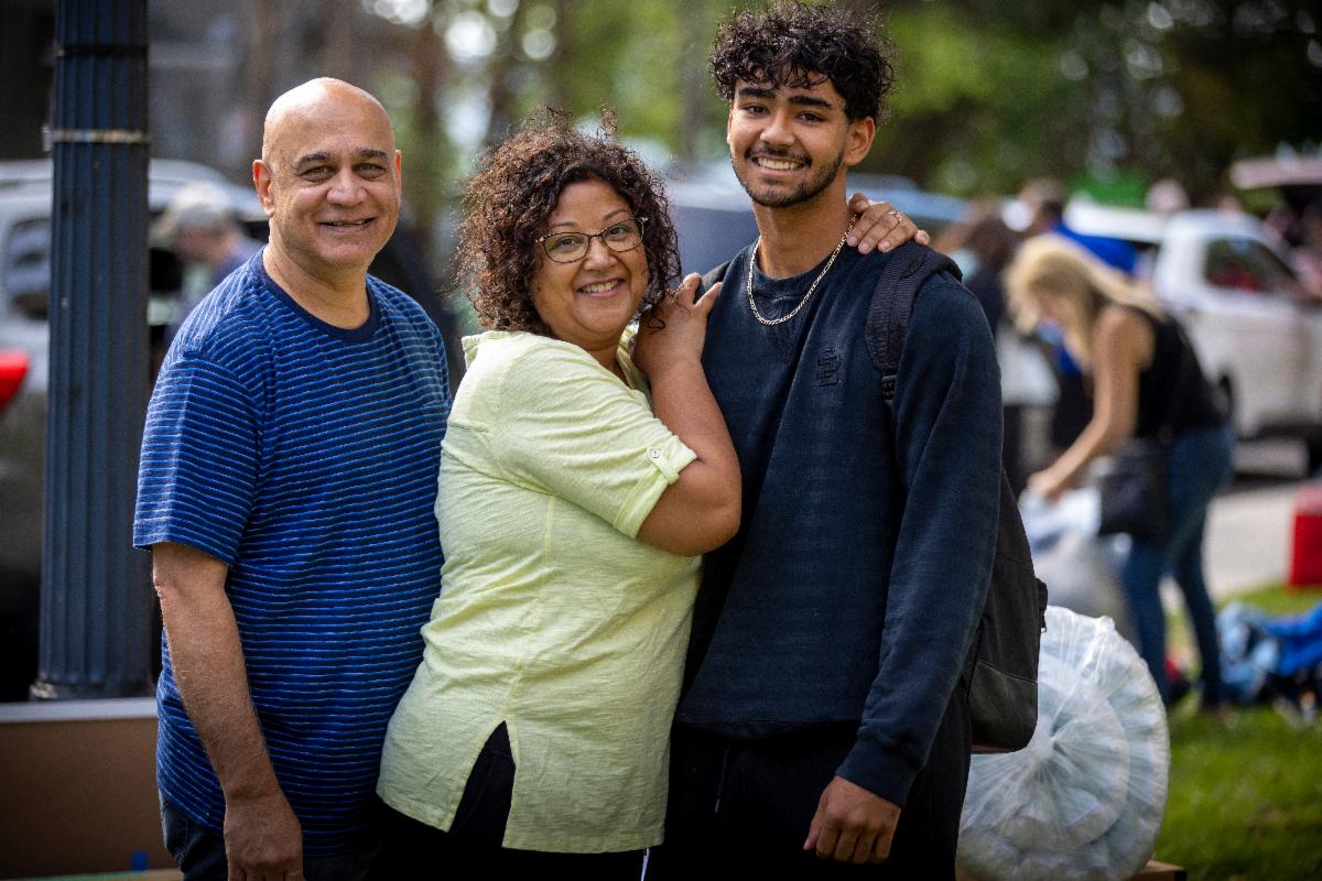 Two parents hug their student on move-in day.