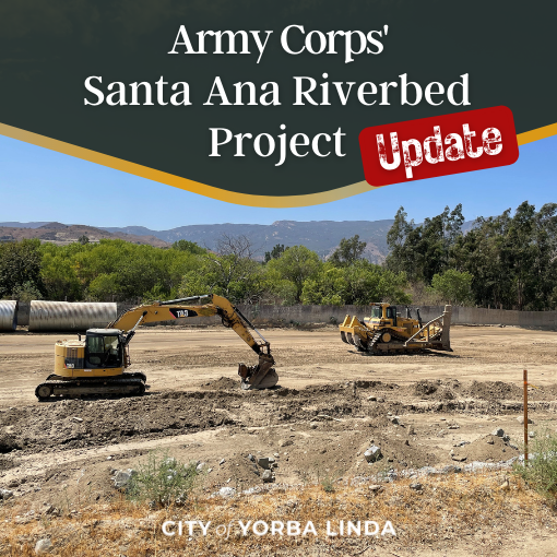 Two tractors moving dirt in a dry riverbed