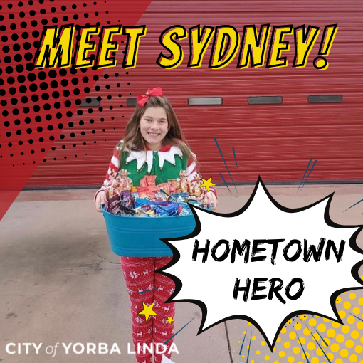 A young girl holds a care package outside a local fire station.