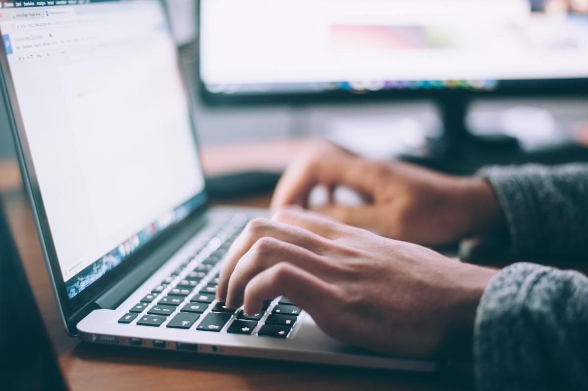 Closeup image of hands typing on a laptop