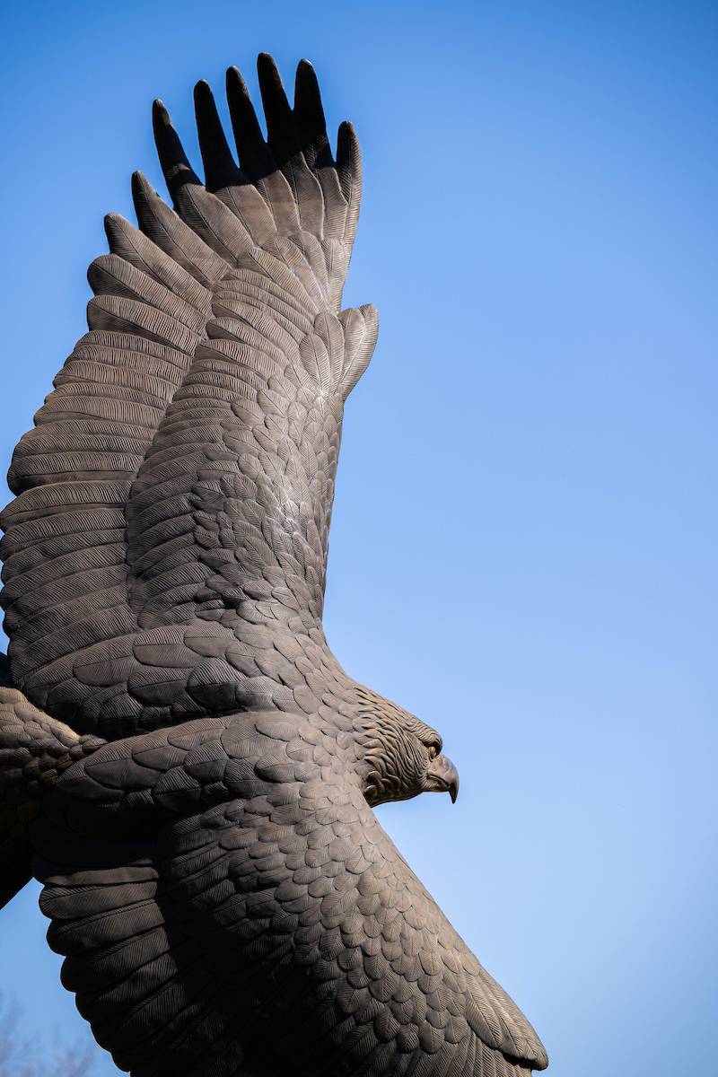 Bronze eagle statue against a blue sky