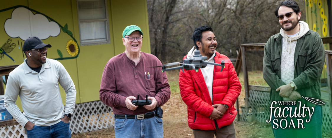 UNT faculty member John South  flying a drone with three students