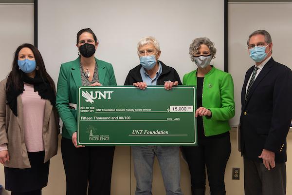 Provost Jennifer Cowley and academic leaders surprise Dr. James Kennedy in class with the UNT Foundation Eminent Faculty Award in the form of a giant check