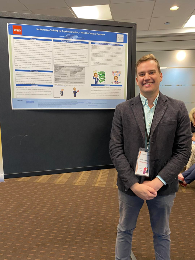A man standing beside a poster