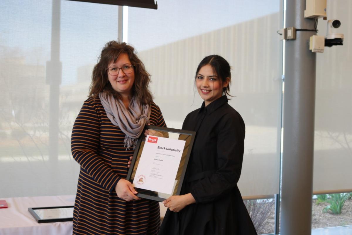 Two women holding an award