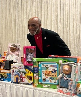 Bill Oliver accepts toys behind a donation table.
