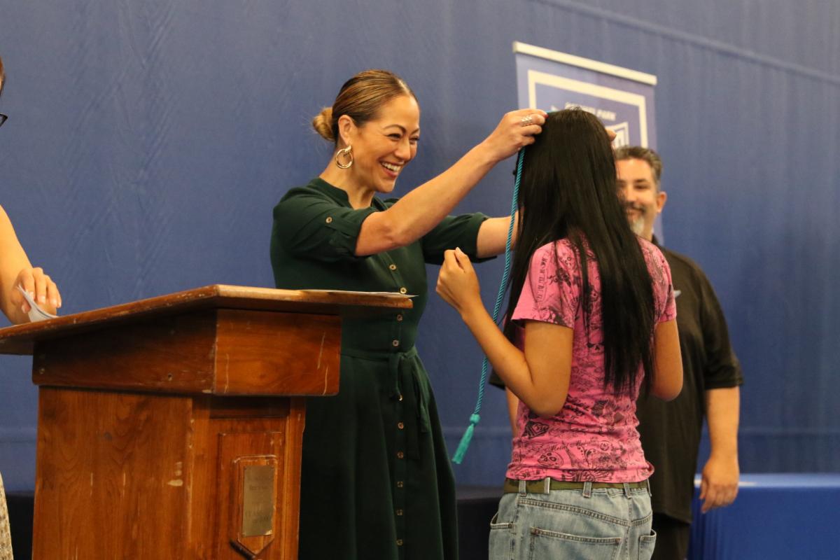 a teacher putting chords over a student's head