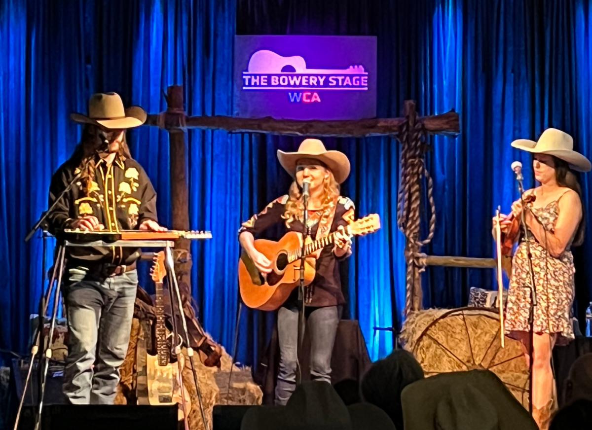 A trio performs music on a stage