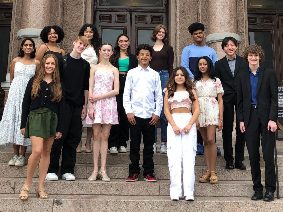 The 15 2024 Young Masters stand outside on the steps of the Texas Capitol building.