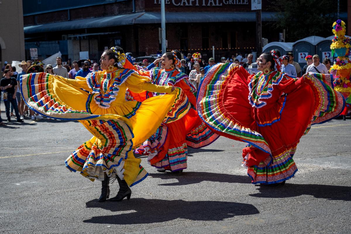 Folklorico dancers swirl their colorful skirts during a parade performance.