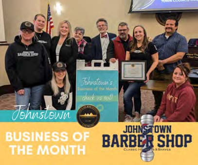 Johnstown Barber Shop employees with Town Council with a sign that says business of the month.