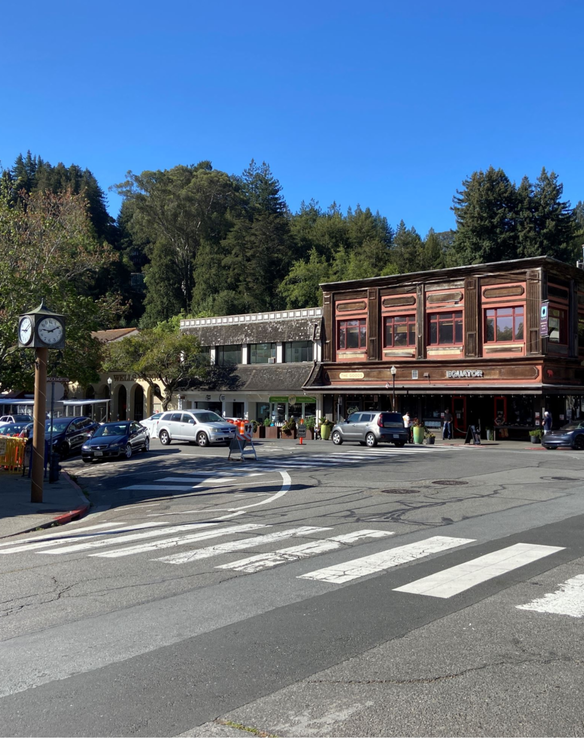 street view of a sunny downtown Mill Valley with local buildings being highlighted in the backdrop of a wooded hillside