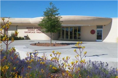 The Marin Center Exhibit Hall and Showcase Theater sits in the sunshine outlines by purple and yellow flowers