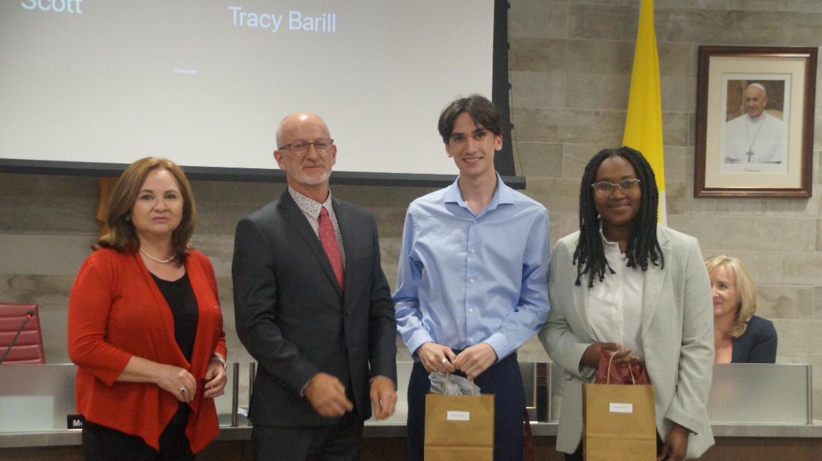 Trustee and Chair of the Board present gifts to the two student trustees