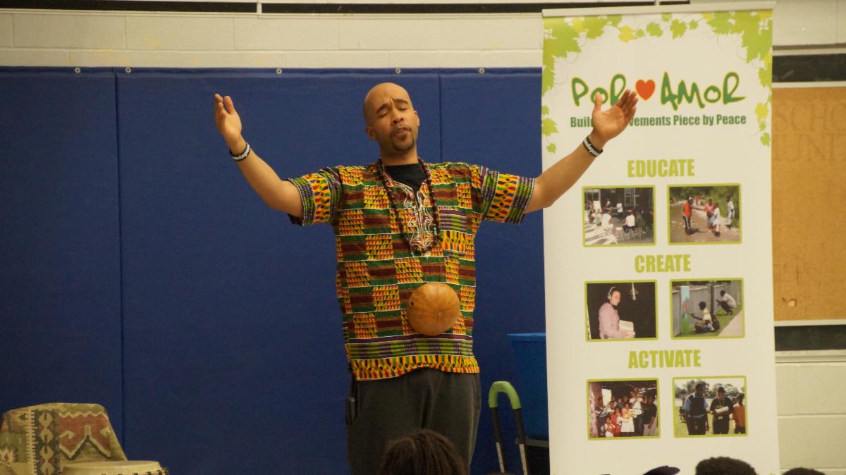 Male adult talking to students about African music 