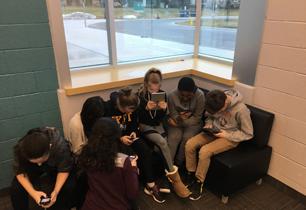 Male and female students texting on phones and ipads talking about mental health