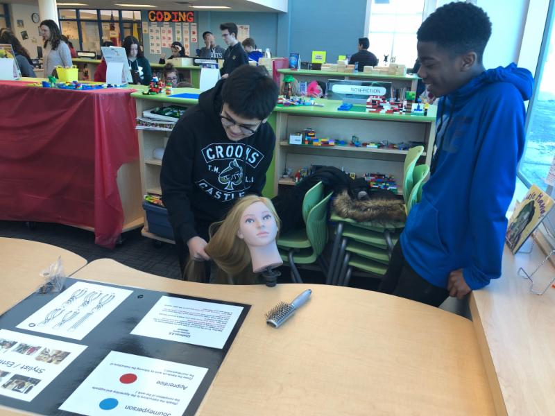 Two male students learning to braid hair