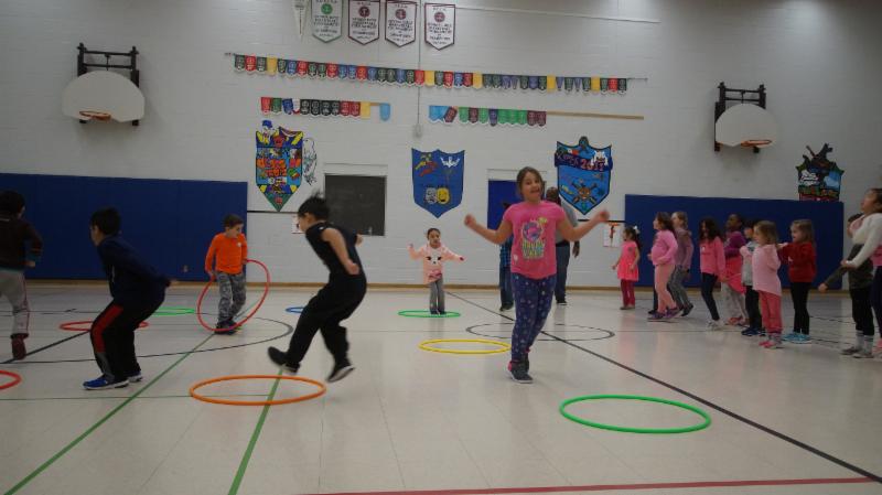 Male and female students participating in physical activity in a school gym to stay healthy