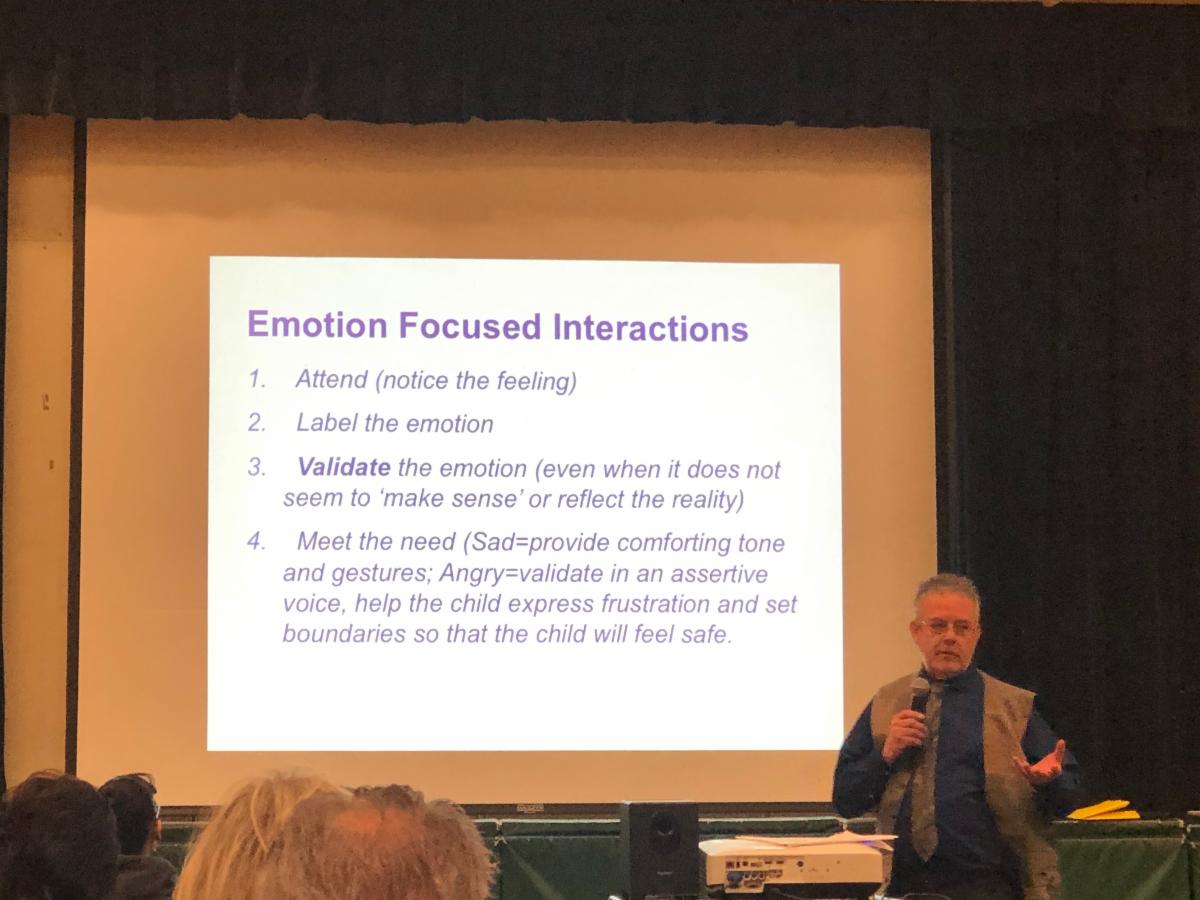 Keynote speaker a male adult speaking to parents about emotional interactions