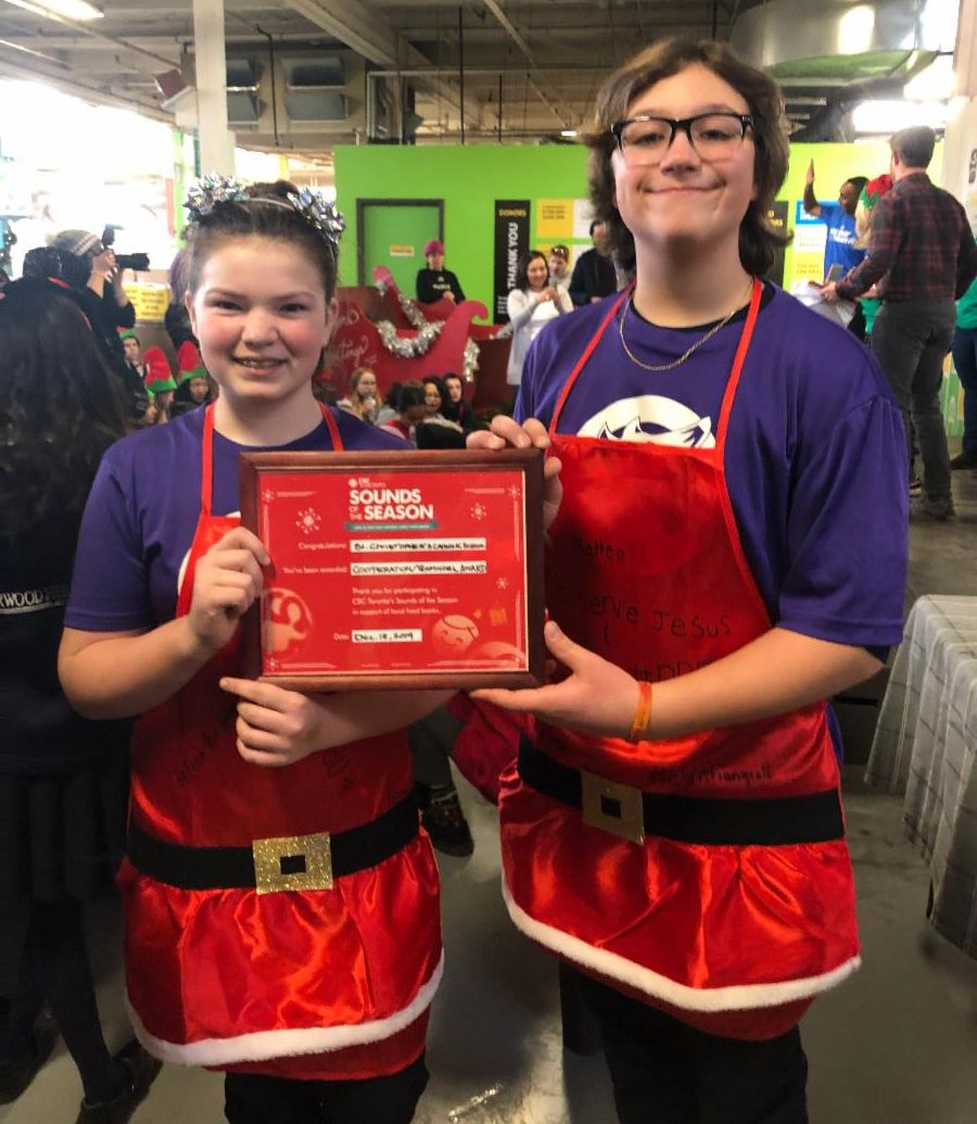 Two female students holding the Cooperation Award from the Daily Food Bank Sorting Challenge.