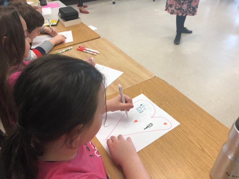 Female student drawing a heart and writing a message to God