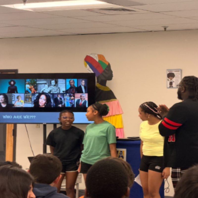 Three students and facilitator hosting a presentation with video