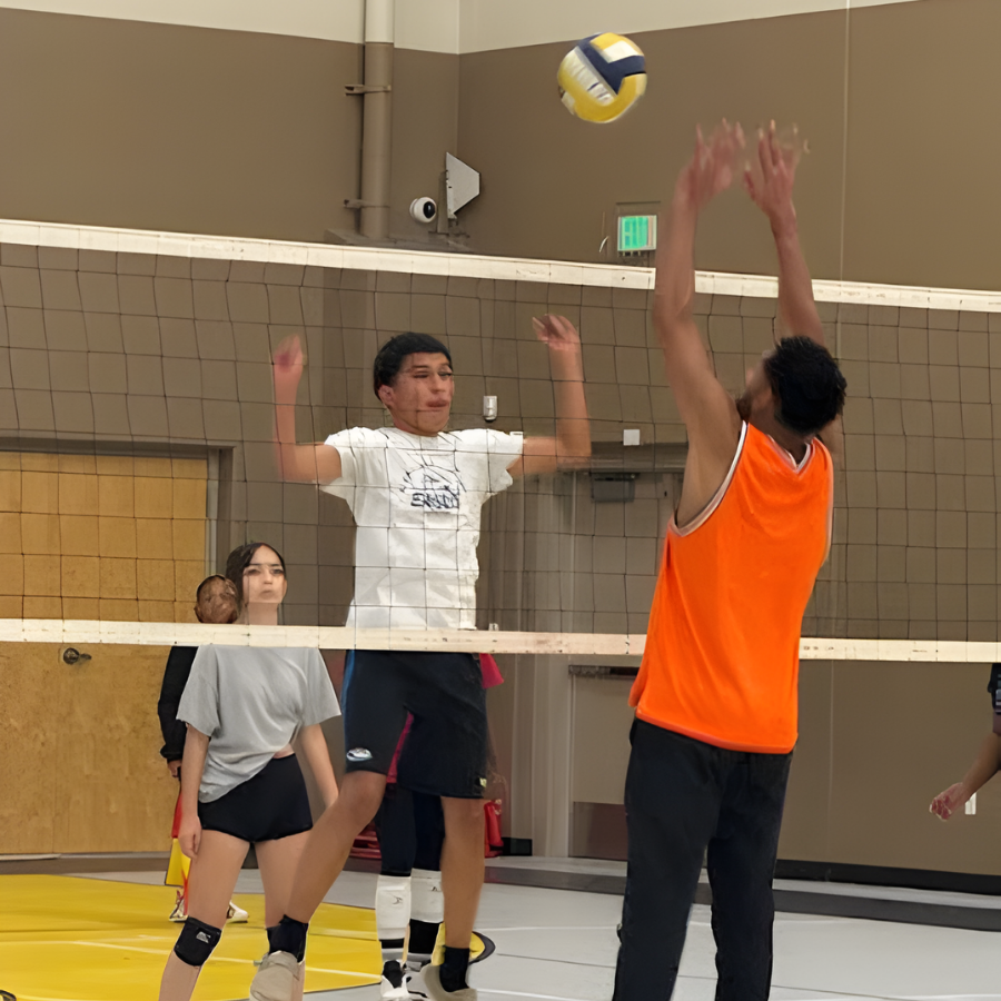 staff and student at the net jumping for ball during volleyball game