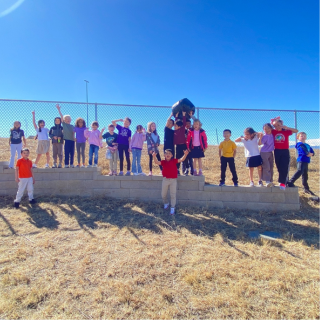 Row of 1st graders standing on a retaining wall 