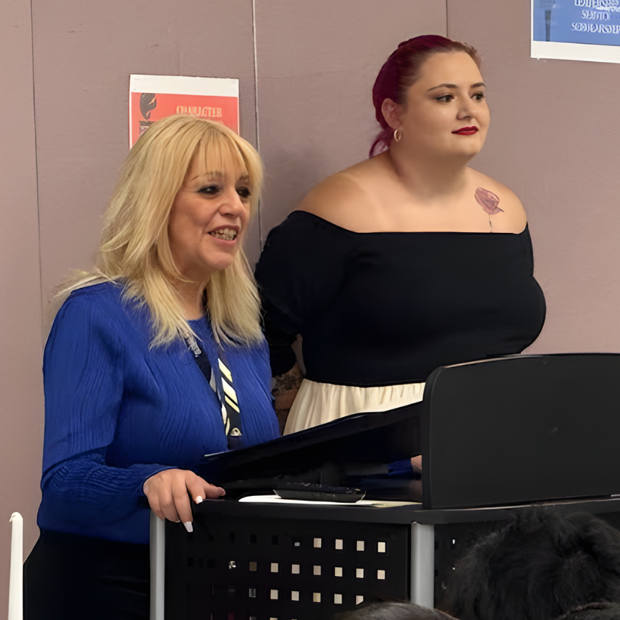 Staff members at a podium speaking at the NJHS ceremony