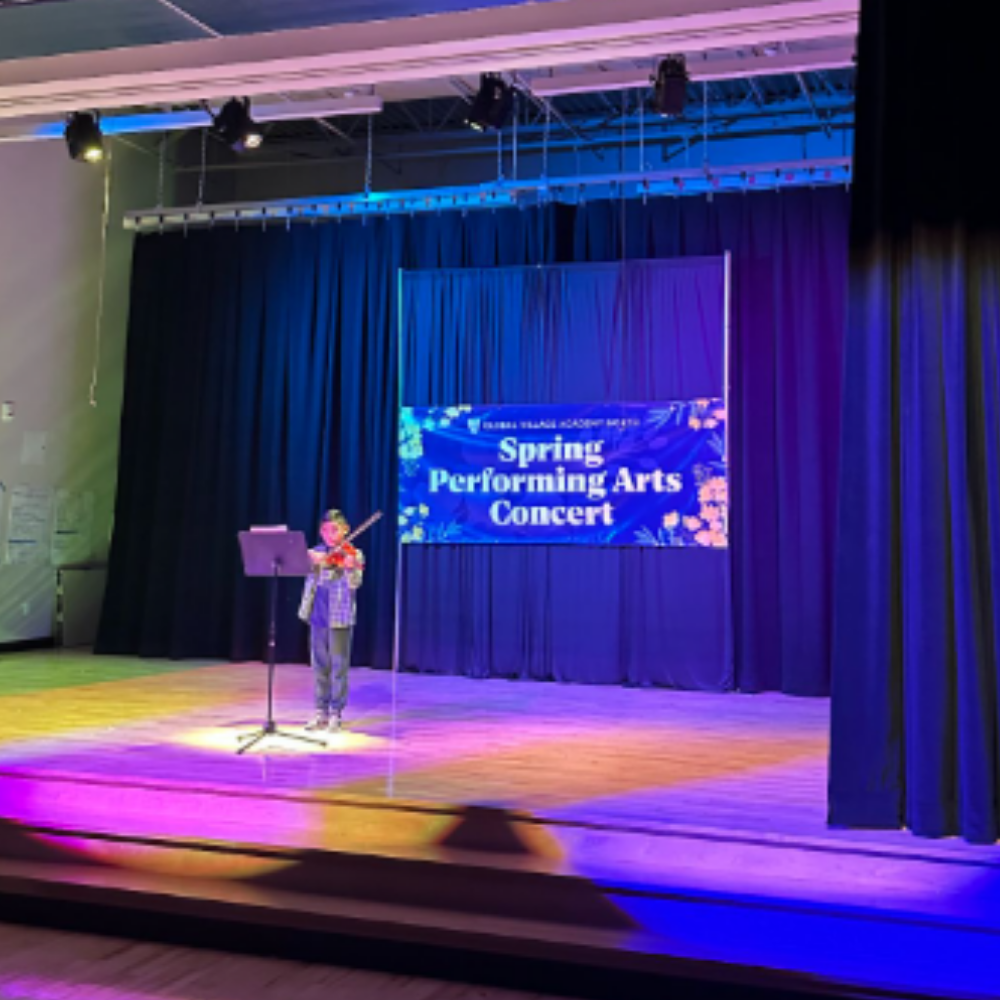 Student on stage playing a violin