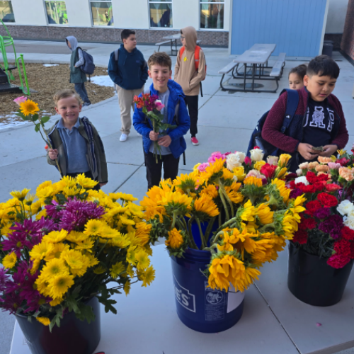 Several students making bouquets from buckets full of flowers