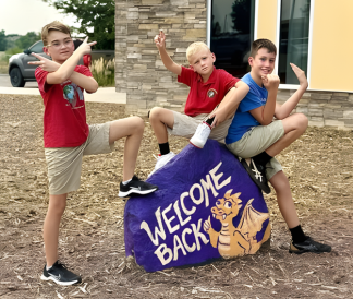 Spirit Rock painted with Welcome Back Dragon and three posing students
