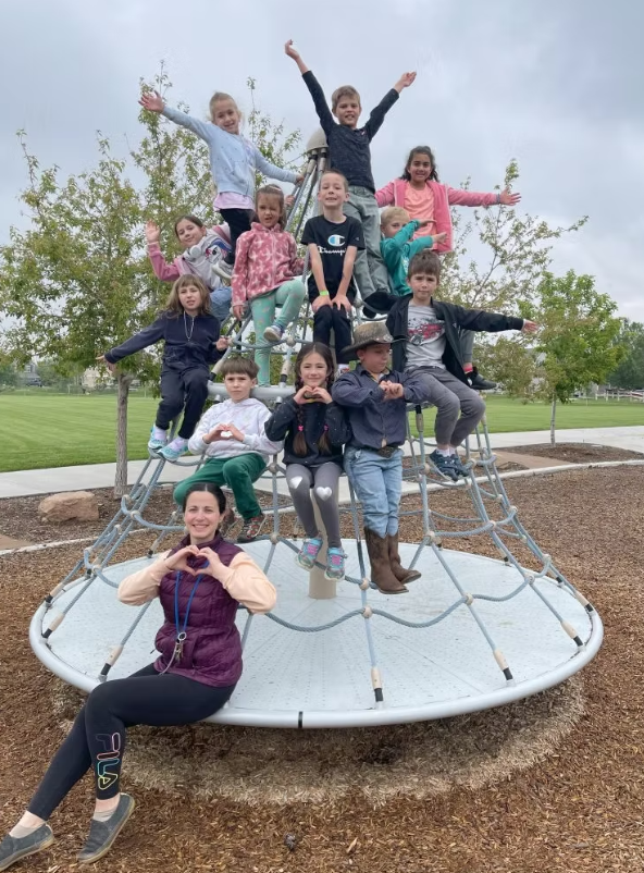 Summer camp students climbing playground equipment
