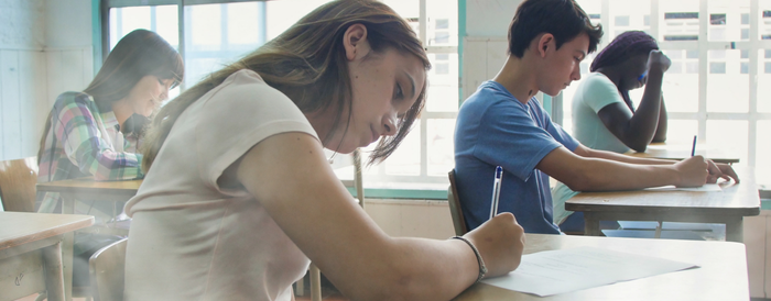 Four middle schoolers taking a test