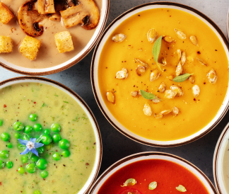Birds eye view of four bowls of different soups