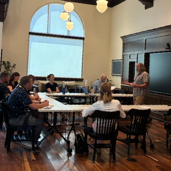 Community members meeting around a table to discuss small business resources in Poweshiek County.