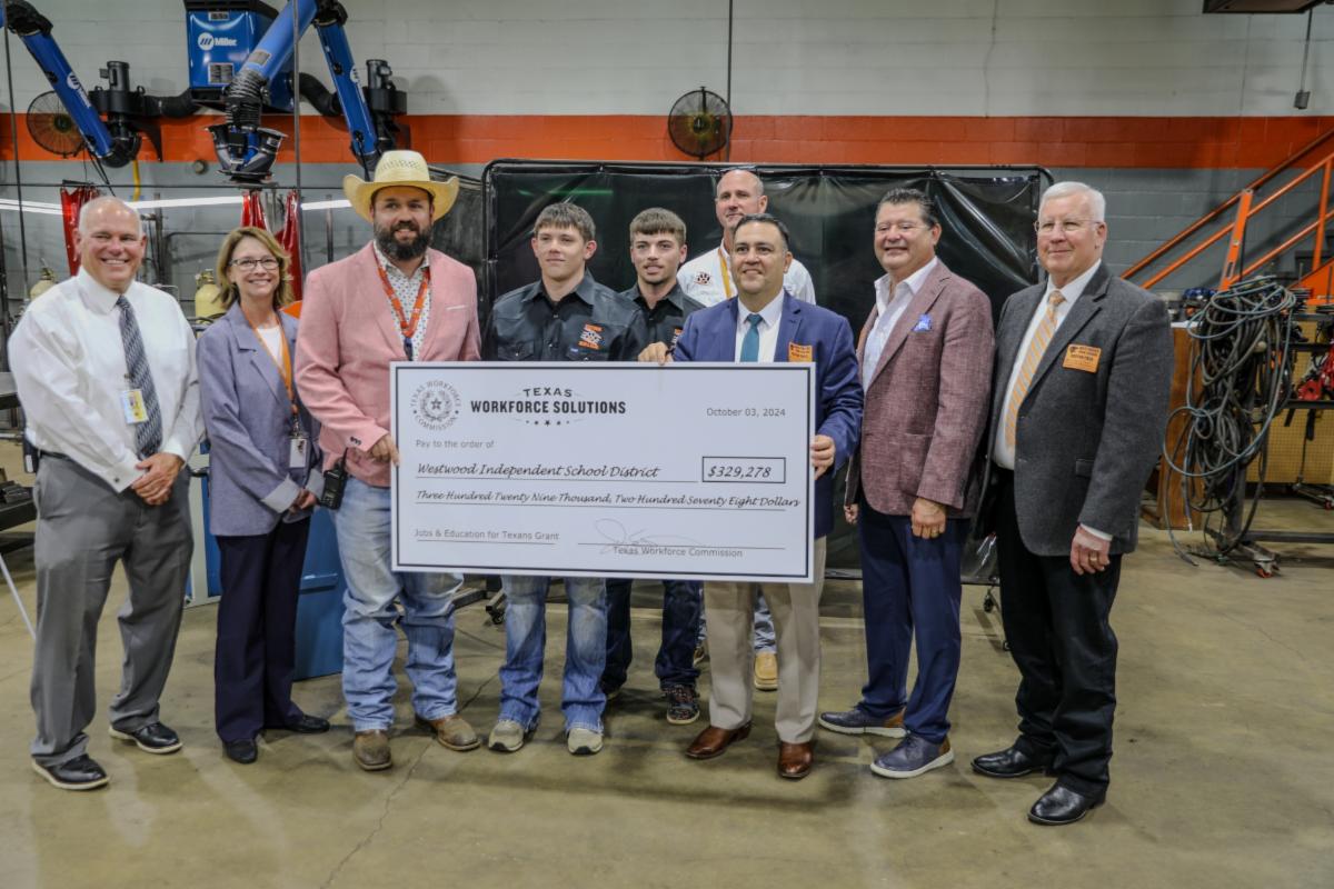group of people holding a giant check