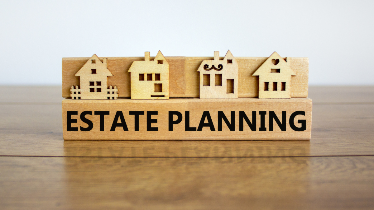 Wooden blocks shaped like houses sit above a block labeled âEstate Planning.â  