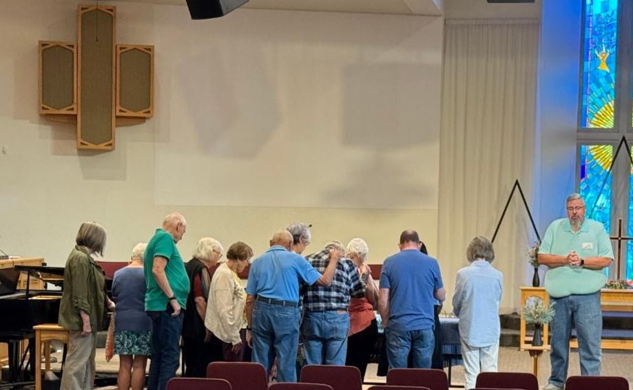 Picture of people at the 8 am service participating in a blessing of the prayer shawls.