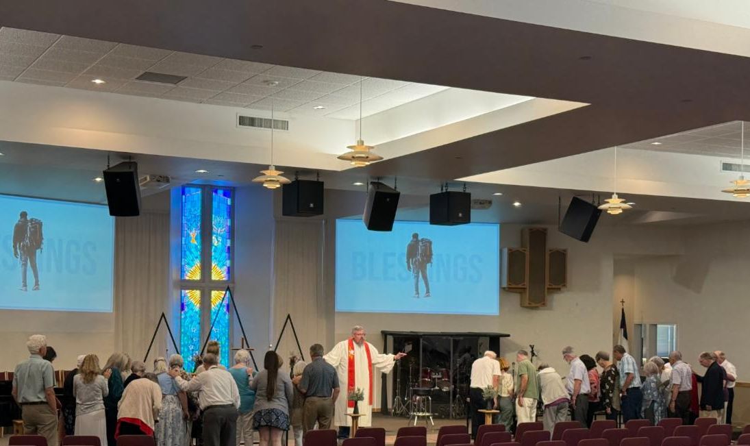Picture of people at the 11 am service participating in a blessing of the prayer shawls.