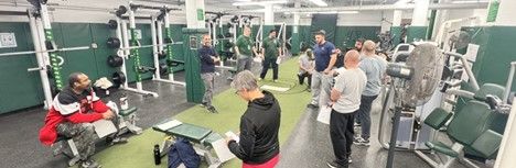 P E teachers in a weight room during professional learning.
