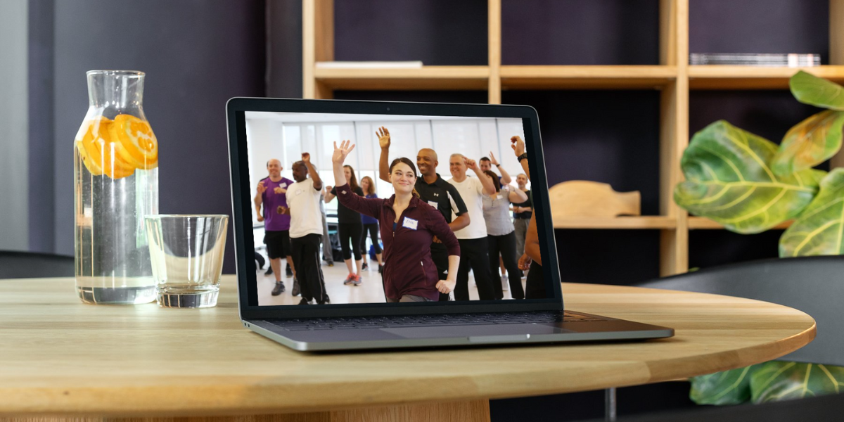 Photo of laptop computer on a desk, with image of teachers doing Move-to-Improve training on the screen.