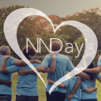 People standing side by side with arms around each other. Photo is taken from behind with a grassy field and tree line in front of the people. Logo of National Nonprofit Day overlays the photo.