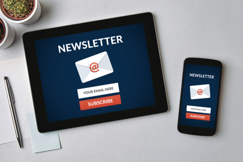 Subscribe newsletter concept on tablet and smartphone screen over gray table. All screen content is designed by me. Flat lay