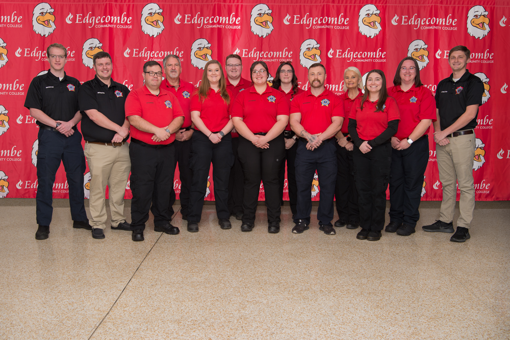 Group of males and females standing in front of large banner with an eagle and Edgecombe Community College logo