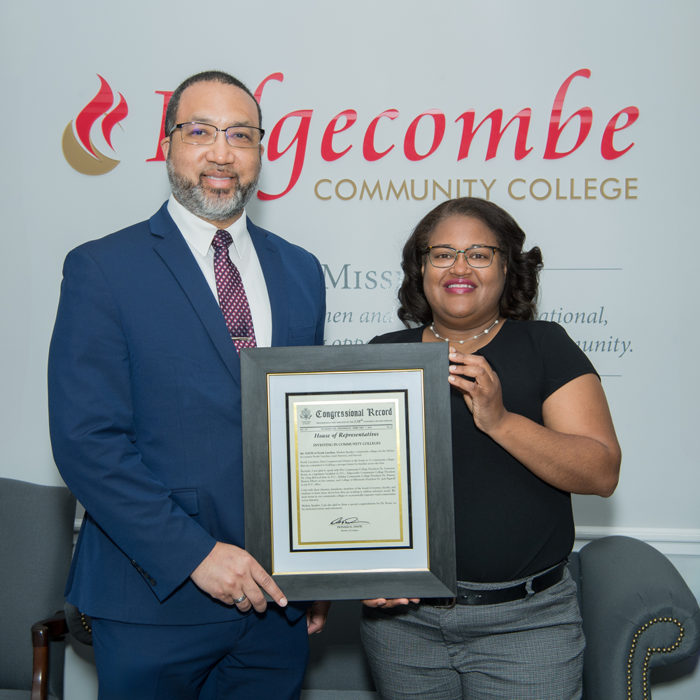 Dr. Greg McLeod poses with female holding framed certificate